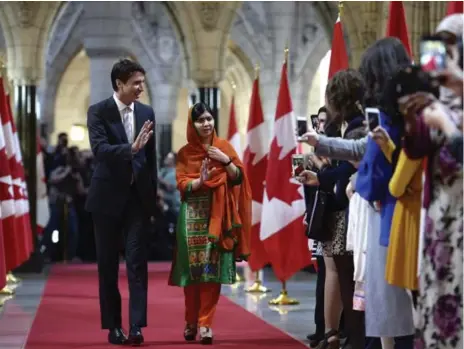  ?? ADRIAN WYLD/THE CANADIAN PRESS ?? Malala Yousafzai greets supporters as she walks through the Hall of Honour with Trudeau. She is only the sixth person to receive the honorary citizenshi­p.