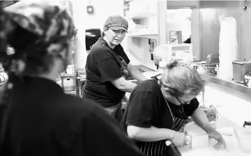  ??  ?? Tryon, left, talks to Pizza Carrello co-owner Ariane Jimison while Janine Dunbar works at right in Gillette, Wyoming.