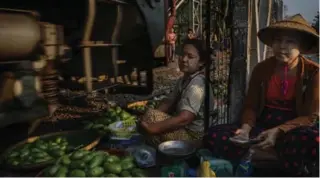  ??  ?? Vegetable vendors right by the tracks at the Danyingon train station.