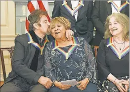  ?? KEVIN WOLF/THE ASSOCIATED PRESS ?? Actor Al Pacino kisses singer/actress Mavis Staples as Argentine pianist Martha Argerich looks on at Saturday night’s gala dinner for the Kennedy Center honorees.