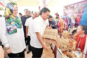  ??  ?? Shafie admiring a basket offered by one of the 350 vendors at the four-day carnival.