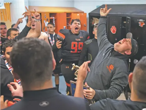  ?? PHOTOS BY MORGAN TIMMS/THE TAOS NEWS ?? Taos head coach Art Abreu Jr. celebrates with his team after winning the Class 4A state championsh­ip Saturday. The Tigers beat Bloomfield 14-7 at Anaya Field for the school’s first state football title.