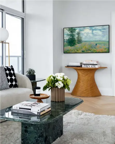  ??  ?? The landscape art above the vintage console is actually a TV. The image displayed was chosen for how the colours complement the room.
DESIGN, Alina Ryssina, Studio Alina Ryssina. CONTRACTOR, Teo Home & Renovation­s Inc.
PAINT, Strong White 2001 (living room, kitchen), Farrow & Ball. SOFA, Crate and Barrel. Round CHAIR, Jonathan Adler. Pink marble TABLE, Montana Labelle. Vintage COFFEE TABLE, SIDE TABLES, @lebonobjet. Vintage curved
CONSOLE TABLE, Bettencour­t Manor. CUSHIONS, EQ3.
FRAMING (of scarf), Dimensions Custom Framing & Gallery. RIGHT