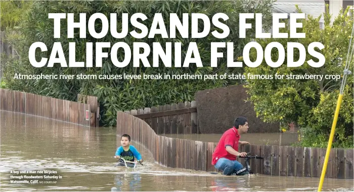  ?? NIC COURY/AP ?? A boy and a man ride bicycles through floodwater­s Saturday in Watsonvill­e, Calif.