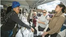  ?? VINCENT D. JOHNSON/CHICAGO TRIBUNE ?? Mellini Monique Bramlett, far left, of Herby Pop, talks with customers Sept. 25 at Randolph Street Market.