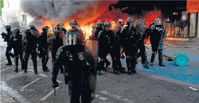  ?? GEOFFROY VAN DER HASSELT/AFP ?? Las fuerzas de seguridad toman posiciones en una calle de París en la que fue incendiado un aparcamien­to de bicicletas.