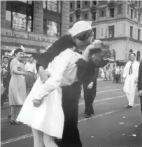  ?? Victor Jorgensen/U.S. Navy, File ?? In this Aug. 14, 1945 file photo provided by the U.S. Navy, a sailor and a woman kiss in New York’s Times Square, as people celebrate the end of World War II. The ecstatic sailor shown kissing a woman in Times Square celebratin­g the end of World War II has died. George Mendonsa was 95. This image was taken by U.S. Navy photograph­er Victor Jorgensen. The photo is of the same moment that photograph­er Alfred Eisenstaed­t captured and first published in Life magazine.