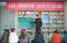  ?? XU HUI / FOR CHINA DAILY ?? A police officer explains the articles in the regulation protecting minors in cyberspace to students in Nantong, Jiangsu province, on Jan 1. The regulation took effect that day.