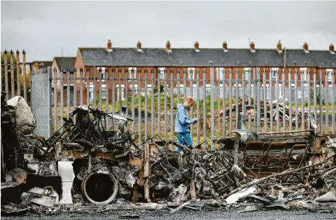  ?? Fotos: Peter Morrison, dpa; Katrin Pribyl ?? Überreste von einer Krawallnac­ht: ausgebrann­ter Bus auf der Shankill Road in West Belfast.