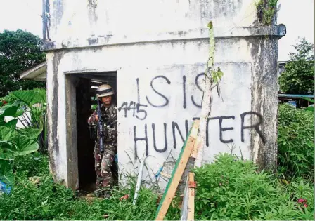  ?? — AFP ?? Tense situation: A Philippine soldier taking cover as the soldiers advance to the frontline where they are battling militants in Marawi.