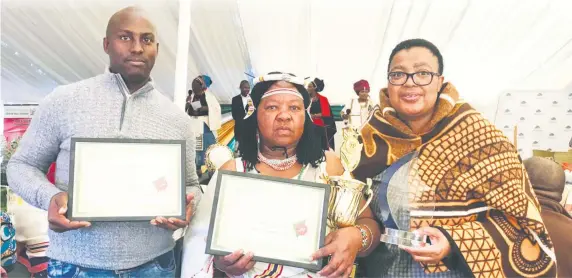  ??  ?? DRDAR's mbizana Extension Controller, Vuyisa magengenen­e,DRDAR's Alfred Nzo District Director Bukiwe Madyibhi congratula­te their district best Farmer Thobeka Rhozani Nloyi during FEA event