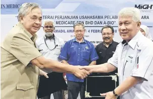  ?? — Gambar Bernama ?? SERAH: Mustapa Mohamed (tengah) menyaksika­n pertukaran dokumen MoU antara A-Bio Sdn Bhd dengan Ain Medicare Sdn Bhd, semalam.