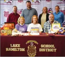  ?? Submitted photo ?? OBU-BOUND: Lake Hamilton senior guard Taylor Wells, center, was joined by her family and coaches as she signed her letter of intent to play basketball at Ouachita Baptist University next year. Joining Wells, in front, from left, were her mother Vicki...