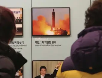  ?? AP ?? ‘TREMENDOUS POWER’: Visitors look at a photo showing North Korea’s missile launch at the Unificatio­n Observatio­n Post in Paju, South Korea.