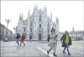  ?? Luca Bruno The Associated Press file ?? A woman wearing a face mask walks by the Duomo cathedral Feb. 23 in Milan, Italy.