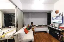  ??  ?? Finance worker Adrian Law eats a delivered meal while watching television in his studio apartment.