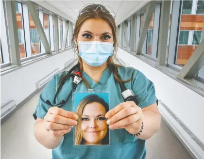  ?? JOHN MAHONEY ?? Royal Victoria Hospital respirator­y therapist Jennifer Hostetter holds a picture of herself at the MUHC'S Glen campus yesterday. Employees clip the photos on their uniforms so patients can see what they look like behind the masks that must be kept on at all times because of COVID-19.