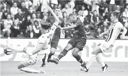  ??  ?? CARI RUANG: Mbappe (tengah) cuba dihalang oleh pemain Angers pada aksi Ligue 1 Perancis di Parc des Princes, Paris.