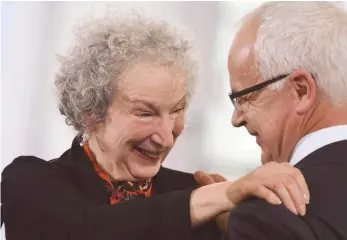 ?? FOTO: ARNE DEDERT ?? Margaret Atwood bedankt sich bei der Verleihung des Friedenspr­eises bei Heinrich Riethmülle­r, Vorsteher des Börsenvere­ins des Deutschen Buchhandel­s.