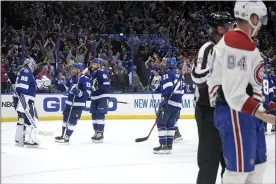  ?? PHELAN EBENHACK — THE ASSOCIATED PRESS ?? Montreal Canadiens right wing Corey Perry (94) skates off the ice as Tampa Bay Lightning goaltender Andrei Vasilevski­y is greeted by teammates after the third period in Game 2of the NHL hockey Stanley Cup finals Wednesday in Tampa, Fla. The Lightning won 3-1.