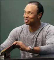  ?? SETH WENIG — THE ASSOCIATED PRESS ?? Golfer Tiger Woods signs copies of his new book in New York, Monday.