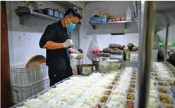  ??  ?? A chef from several Michelin-starred restaurant­s prepares ingredient­s for food boxes to be distribute­d to the poor, in the kitchen of Chin By Siam Wisdom restaurant.