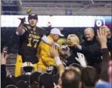  ?? DARIN OSWALD — IDAHO STATESMAN VIA AP ?? Wyoming quarterbac­k Josh Allen (17) passes potatoes from the Famous Idaho Potato Bowl trophy to his teammates following the team’s 37-14 victory over Michigan Friday in Boise, Idaho. Central