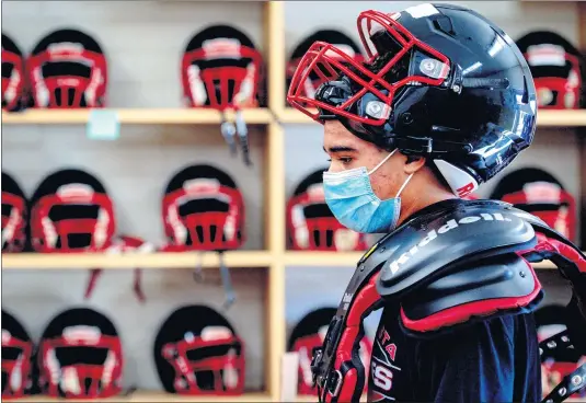  ?? PHOTOS BY WATCHARA PHOMICINDA — STAFF PHOTOGRAPH­ER ?? Keenan Stoddard tries on his equipment at Norte Vista High School in Riverside on Tuesday. Riverside County is allowing football and other outdoor contact sports to resume competitio­n as coronaviru­s cases continue to drop. “I’m excited and I know our kids are excited,” coach Ken Batdorf said. “This is the longest football season I’ve been a part of.”