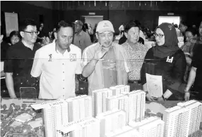  ??  ?? Hajiji (middle) gestures as he views the scale model of the PRIMA Homes@Manggatal dubbed “Residensi PR1MA Menggatal”. Also seen (from right) are Rozita, Chu,Yakub and Suken.