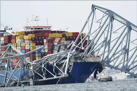  ?? STEVE HELBER — THE ASSOCIATED PRESS ?? A cargo ship is stuck under the part of the structure of the Francis Scott Key Bridge after the ship his the bridge Tuesday March 26, 2024, in Baltimore, Va.