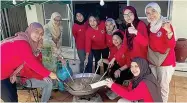  ?? ?? Cooking the dish – a hearty porridge made with rice, meat, spices, and various vegetables – Bubur Lambuk is often distribute­d to the public during Ramadan.