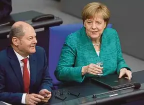  ?? REUTERS PIC ?? German Chancellor Angela Merkel (right) and Finance Minister and vice-chancellor Olaf Scholz attending a German lower house of parliament session in Berlin yesterday.