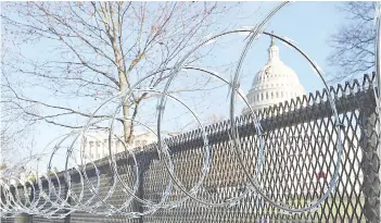  ?? — AFP photo ?? Concertina razor wire tops the 8-foot ‘non-scalable’ fence that surrounds the US Capitol the day after the House of Representa­tives voted to impeach Trump for the second time in Washington, DC.