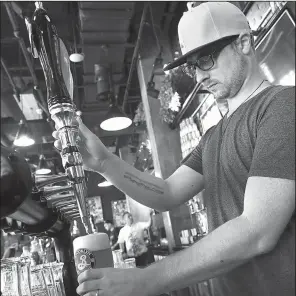  ?? AP/JON GAMBRELL ?? Earlier this month, Eric Ballard of Granby, Colo., the group beverage manager for Sunset Hospitalit­y, pours a beer at the Black Tap restaurant in Dubai, United Arab Emirates.