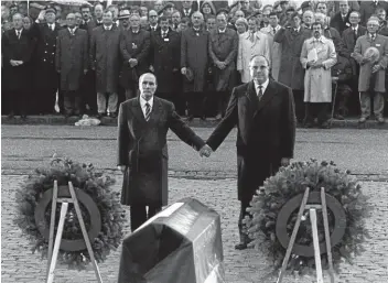  ??  ?? September 1984: Hand in Hand stehen Helmut Kohl und Frankreich­s Präsident Mitterrand an den Gräbern von Verdun.