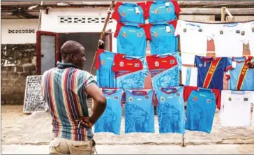  ?? EDUARDO SOTERAS/AFP ?? A man stands at a stall selling Congolese national football team shirts in Kinshasa, the capital city of Democratic Republic of the Congo, on Wednesday.