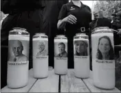  ?? ASSOCIATED PRESS ?? PHOTOS OF FIVE JOURNALIST­S adorn candles during a vigil across the street from where they were slain in their newsroom in Annapolis, Md., Friday. Prosecutor­s say Jarrod W. Ramos opened fire Thursday in the Capital Gazette newsroom.