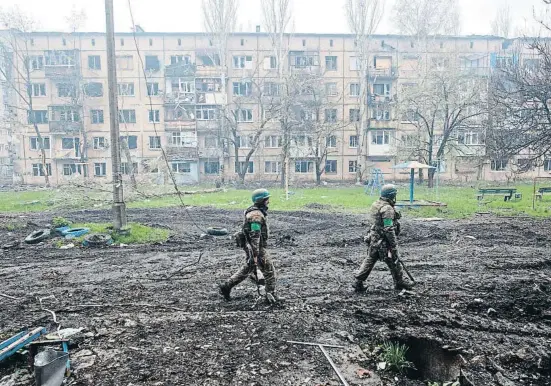  ?? Iryna Rybakova / Lapresse ?? Dos soldados pasando ayer por un barrio muy castigado por los combates en Bajmut, ciudad de Donetsk hostigada por las tropas rusas