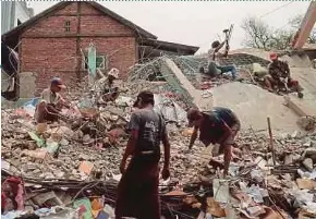  ?? AFP PIC ?? People sifting through the rubble of a collapsed building in Mandalay on Saturday.