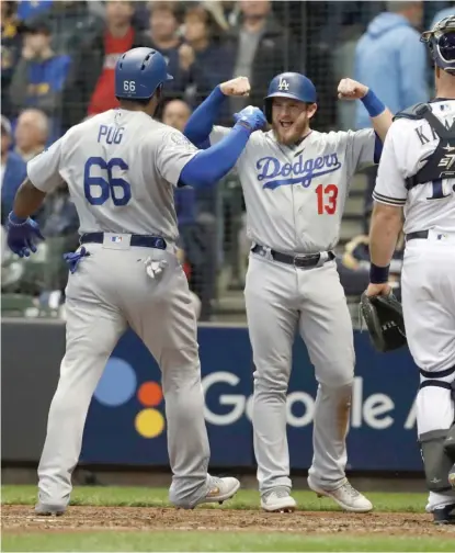  ?? AP ?? The Dodgers’ Yasiel Puig celebrates with Max Muncy after hitting a three-run homer in the sixth inning of Game 7 on Saturday.