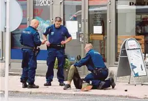  ?? AFP PIC ?? Policemen with an injured person in the Finnish city of Turku where several people were stabbed yesterday.