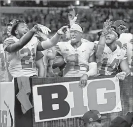  ?? AJ Mast Associated Press ?? OHIO STATE football players celebrate their victory over Wisconsin in the Big Ten championsh­ip game. The Buckeyes’ victory complicate­s the playoff picture.
