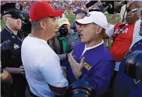  ??  ?? LSU coach Les Miles, right, talks to Wisconsin coach Paul Chryst after Wisconsin’s 16-14 win this past Saturday at Lambeau Field in Green Bay, Wis. Miles’ Tigers entered the game with a top-five ranking and plenty of optimism, but the unranked Badgers...