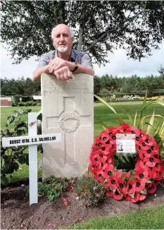  ??  ?? Geoff Mcmillan at the grave of his Uncle Charlie