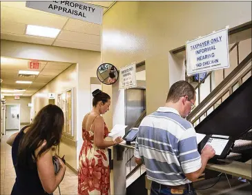  ?? NICK WAGNER / AMERICAN-STATESMAN ?? Property owners check in at the Travis County Appraisal District office in May. The Austin City Council has raised property taxes by more than 4 percent — above which Senate Bill 1 would force cities and counties to seek voter approval to hike taxes —...