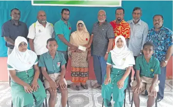  ?? Photo: Shratika Naidu ?? Aikay Builders director Shahrufh Shah (standing third from the left) with his mother Asha Bi handover cheque to the management of Bocalevu Muslim Primary School in Labasa on September 26,2018.
