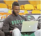  ?? STAFF PHOTO BY STUART CAHILL ?? LAST MINUTE STUDY: Semi Ojeleye looks over a computer prior to last night’s Game 7 between the Celtics and Bucks at the Garden.