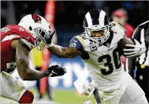  ?? MATT DUNHAM / AP ?? Rams running back Todd Gurley straight-arms Cardinals linebacker Deone Bucannon en route to a 106-yard rushing performanc­e during Sunday’s 33-0 victory in London.