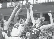  ?? Sean Rayford / Associated Press ?? South Carolina’s A’ja Wilson (22) found it tough to score against the defense of Connecticu­t’s Katie Lou Samuelson (33) and Napheesa Collier on Thursday.