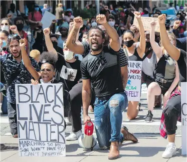  ??  ?? Anti-racism demonstrat­ors take a knee near Toronto Police Headquarte­rs during a march on June 6, protesting the death of George Floyd, who died May 25 after being restrained by police in Minneapoli­s. As many of the protesters have noted over the past couple of weeks, Canada has its own shameful past regarding racism, Monique Keiran writes.